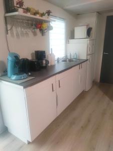 a kitchen with white cabinets and a counter top at Mobil home climatisé au Domaine Lalande à Mimizan in Mimizan