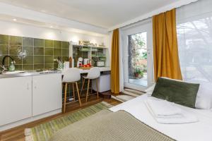 a living room with a white couch and a kitchen at Origo Vendégház in Hévíz