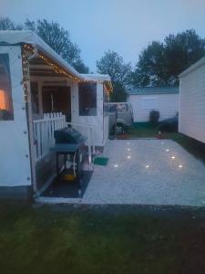 a white trailer with a grill in a yard at Mobil home climatisé au Domaine Lalande à Mimizan in Mimizan