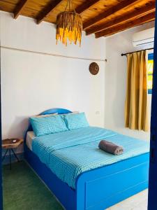 a blue bed in a white room with a blue comforter at Blue House in Lighthouse in Dahab