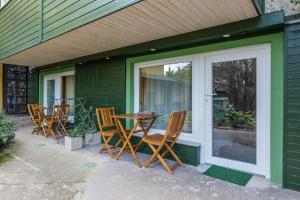 a patio with chairs and a table next to a door at Origo Vendégház in Hévíz