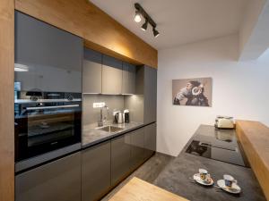 a kitchen with gray cabinets and a counter with cups on it at Ferienwohnung Hammerwirt in Fieberbrunn