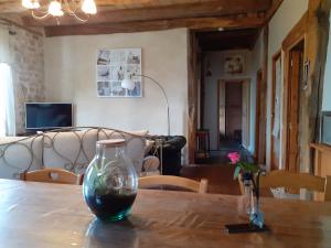 szklaną wazę siedzącą na drewnianym stole w obiekcie Gîte le relais de la diligence w mieście Saint-Lazare