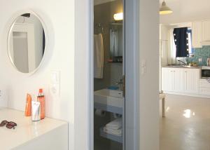 a white bathroom with a sink and a mirror at Kallichoron Country Houses in Astypalaia Town