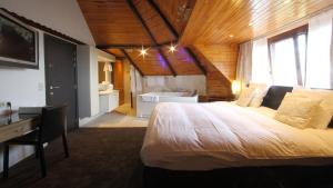 a bedroom with a large bed and a bathroom at Hostellerie Kemmelberg in Kemmel