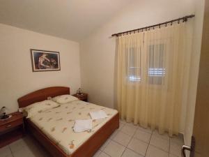 a bedroom with a bed and a window at Keran 4 in Podgora