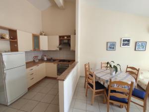 a kitchen with a table and a white refrigerator at Keran 4 in Podgora +10 photos