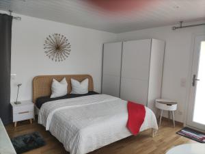 um quarto branco com uma cama com um cobertor vermelho em Beau studio avec terrasse et vue EXCLUSIVEMENT POUR NON FUMEURS em Belmont-sur-Lausanne