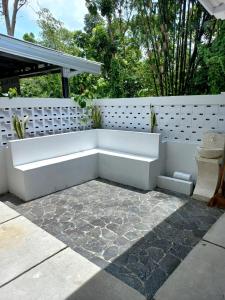 un banc blanc installé au-dessus d'une terrasse dans l'établissement rindoe jogja holiday home, à Yogyakarta
