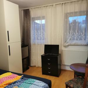 um quarto com uma cama, uma cómoda e uma janela em Dom wczasowy Maja em Dźwirzyno