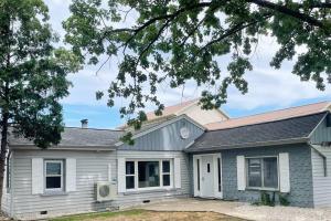 une maison blanche avec un toit gris dans l'établissement Waterfront Cottage near Lambeau and Door County!, à Green Bay