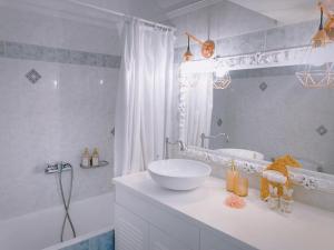 a white bathroom with a sink and a tub at Fairy home Porto Heli in Porto Heli