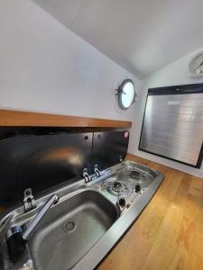 a kitchen with a sink in a room with a window at Holländisches Kajütboot Nixe in Bremen