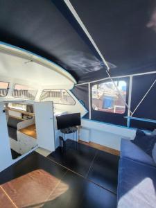 une chambre avec un canapé et un bureau dans un bateau dans l'établissement Holländisches Kajütboot Nixe, à Brême