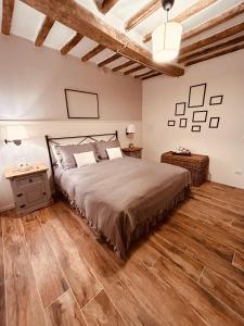 Schlafzimmer mit einem Bett und Holzboden in der Unterkunft Il Cavallo a Dondolo in Abbadia San Salvatore