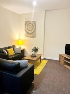 a living room with a couch and a tv at Two Bed Town Apartment in Rotherham