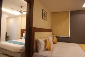 a bedroom with two beds with yellow pillows at Hotel The Prime in Hyderabad