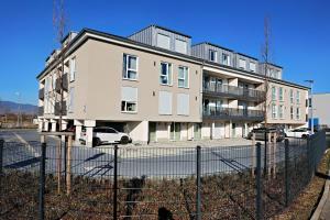 un gran edificio de apartamentos con una valla delante en helloYOU Apartments, en Ingelheim am Rhein