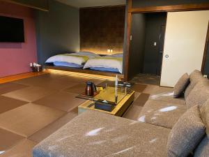 un soggiorno con letto, divano e specchio di 那古井館別邸　玉響[TAMAYURA] a Tamana