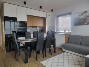 a kitchen and dining room with a table and chairs at Apartament MAJA (przy Aquaparku w Redzie) in Rumia