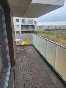 a balcony with a table and a yellow chair at Apartament MAJA (przy Aquaparku w Redzie) in Rumia