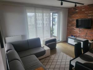 a living room with a couch and a tv at Apartament MAJA (przy Aquaparku w Redzie) in Rumia