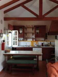 a kitchen with wooden cabinets and a table in a room at BREJOS DA COMENDA by Stay in Alentejo in Vila Nova de Milfontes