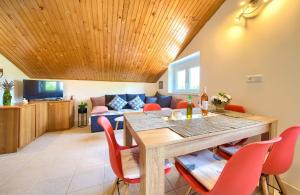 ein Wohnzimmer mit einem Tisch und roten Stühlen in der Unterkunft Apartment Lipovac in Malinska