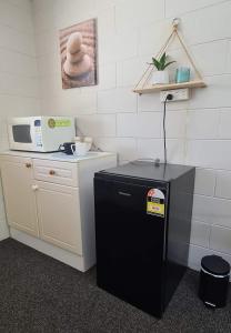 a small refrigerator in a kitchen with a microwave at Bramston beach resort in Bramston Beach