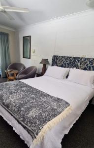 a bedroom with a large bed and a chair at Bramston beach resort in Bramston Beach