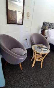 two chairs and a table in a room at Bramston beach resort in Bramston Beach