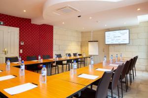 a conference room with tables and chairs with water bottles on them at Hôtel Grand Monarque in Azay-le-Rideau
