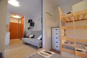 a small room with a bunk bed and a bedroom at Apartamenty Poddąbie z ogródkiem in Poddąbie