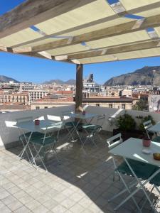 un patio con mesas y sillas y vistas a la ciudad en La Terrazza su Palermo, en Palermo