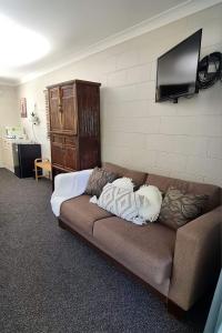 a couch in a room with a television on a wall at Bramston beach resort in Bramston Beach