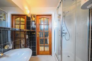 a bathroom with a shower and a sink and a mirror at Zielony by OneApartments in Sopot