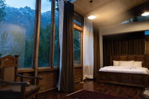 a bedroom with a bed and a large window at Old Hunza inn in Hunza Valley