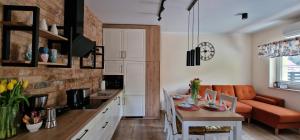 a kitchen and living room with a table and a couch at Apartament Łomnicka 59 in Jelenia Góra