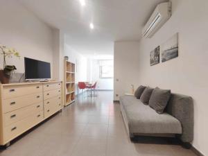 a living room with a couch and a television in it at Mazi Apartments Nest in Mataró