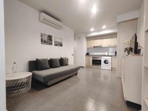 a living room with a couch and a kitchen at Mazi Apartments Nest in Mataró