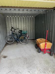 a bicycle and a cart in a garage at Deichblick-Carolienensiel in Carolinensiel