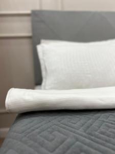 un primer plano de una cama con una almohada blanca en ЖК - 4 YOU - Nomaden- 3 en Almaty