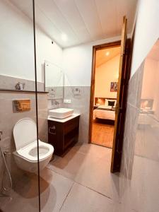 un baño con inodoro y lavabo en Yaato Retreat, en Manali 8 fotos más