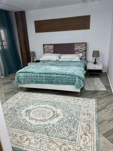 a bedroom with a large bed and a rug at Hotel al rayan in Tataouine