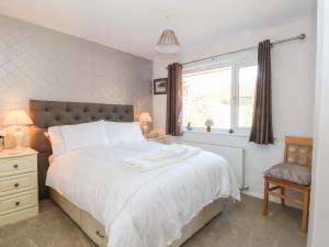 a bedroom with a large white bed and a window at 7 Marl Croft in Chester
