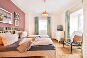 1 dormitorio con 2 camas y 1 silla en Ferienwohnungen im Bürgermeisterviertel en Stralsund