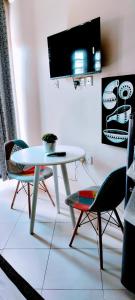 Khalisee Homes Studio Apartment 2 في Voi: طاولة بيضاء وكراسي في غرفة