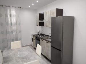 a kitchen with a refrigerator and a table and chairs at Casa vacanze Venere in Balestrate