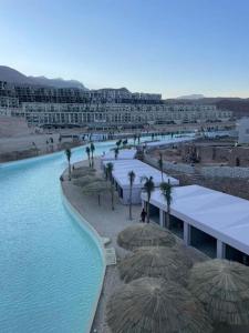 a swimming pool with umbrellas and a resort at Lagoon View 2 Bedroom IL Monte Galala Ain Sokhna C2-CH28-2-1 in Ain Sokhna