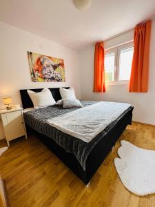 a bedroom with a large bed and orange curtains at Apartments Imperium in Trogir +84 photos